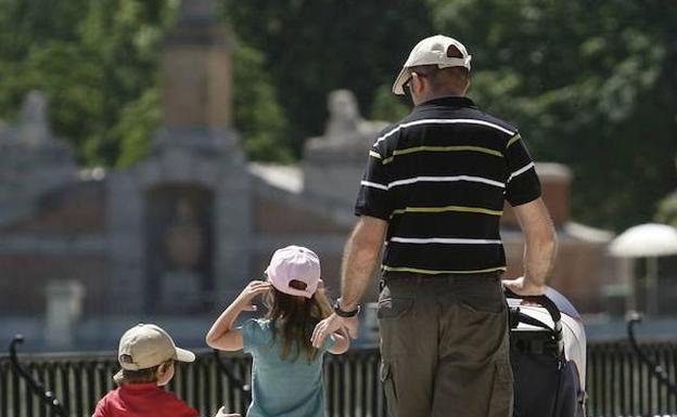 Una familia pasea por el Parque del Retiro.