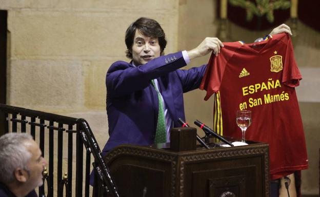 Javier Ruiz, juntero del PP, muestra una camiseta de la seleccion española, para pedir que juegue en San Mames durante el pleno de Juntas Generales.