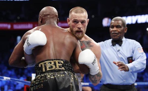 Conor McGregor y Floyd Mayweather se agarran durante el combate.