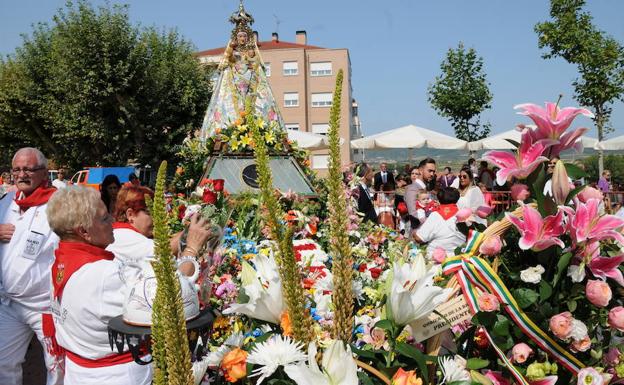 La imagen de la patrona aparece envuelta por los ramos y centros que le llevaron las instituciones, entidades y vecinos de la ciudad a lo largo del acto celebrado en los Jardines de la Vega.