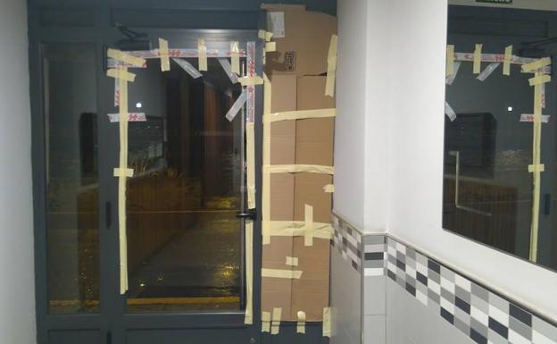 Así ha quedado el portal, después de que vándalos reventaran el cristal y desencajaran la puerta.