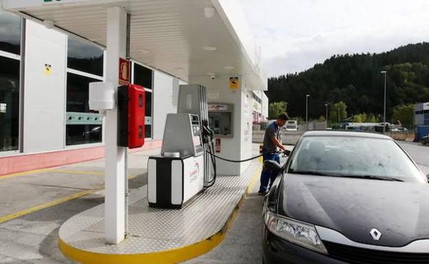 Un hombre reposta gasolina.