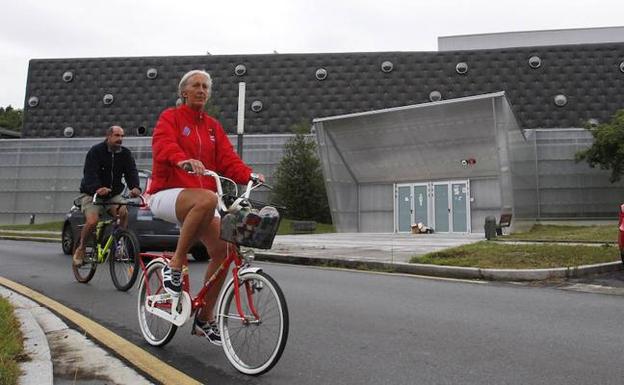 Dos vecinos pasean en bicicleta frente al polideportivo de Bakio. / M. S.