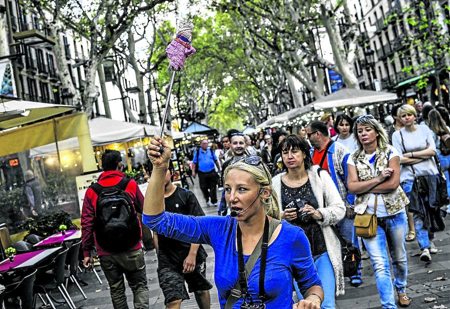 Una guía señala el camino a un grupo de turistas en la siempre masificada Rambla de Barcelona./Ignacio Pérez