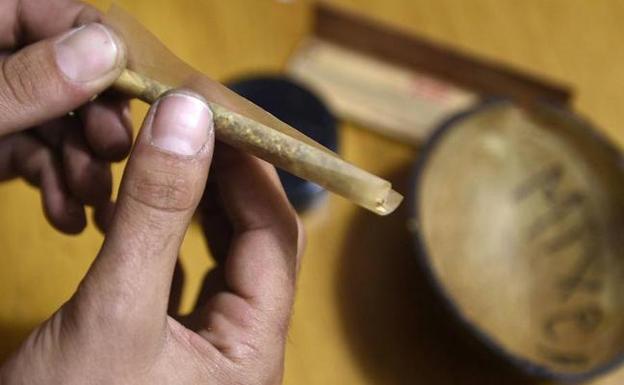 Un usuario se lía un porro en un club de Barcelona. /AFP