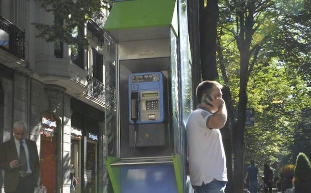 Un hombre, junto a una cabina en Bilbao./MAITE BARTOLOMÉ