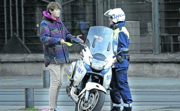 Un joven conversa con un policía tras ser multado durante una de las jornadas de ‘huelga de celo’. /Rafa Gutiérrez