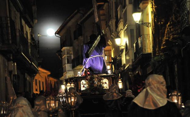 El paso que representa la primera caída de Cristo en el camino hacia el Calvario recorre las calles de Haro, con la luna llena en segundo plano./ R. SOLANO