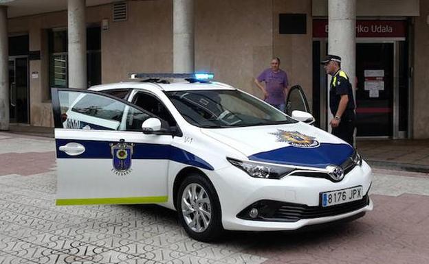 Un agente se acerca a un vehículo policial. / L.P.