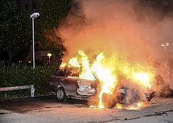 Vista de un vehículo en llamas tras los disturbios registrados en el barrio de Kista, en Estocolmo. / Efe | Vídeo: Atlas/