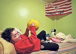 Iván juega a la pelota en su habitación vestido con la equipación del Athletic, club del que es hincha absoluto. /Borja Agudo/