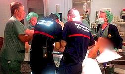Bomberos, cirujanos y personal sanitario durante la operación para cortar el tubo./