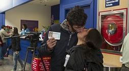 La pareja se besa mientras muestra el décimo premiado. / Celedonio/
