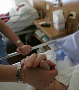 Una cuidadores atiende a un anciano. / N. GONZÁLEZ/