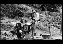 Niños y mujeres cogen agua de la fuente./ 'OCHARCOAGA'/