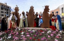 Los Reyes Magos, acompañados por el alcalde, posan con la escultura navideña./