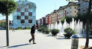 Un hombre atraviesa la plaza de la Estación, en Las Arenas. / PEDRO URRESTI/