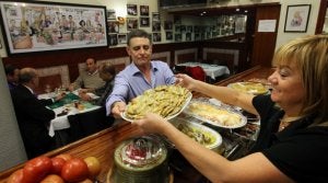 Feli Prada pone en manos de su marido, Abelardo García, gestores de la 'La Viña' de Henao, una bandeja de anchoas rebozadas. :: MIREYA LÓPEZ/