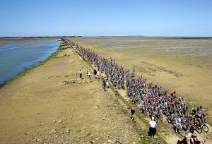 El pelotón del Tour rueda compacto por el Paso de Gois, una carretera al nivel del mar, accesible sólo cuando hay marea baja. ::
EFE/