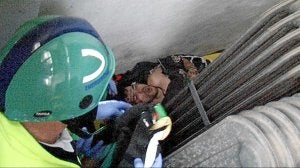 Un sanitario intenta acceder hasta el hueco donde quedó atrapado Mohamed./ Luis Calabor/