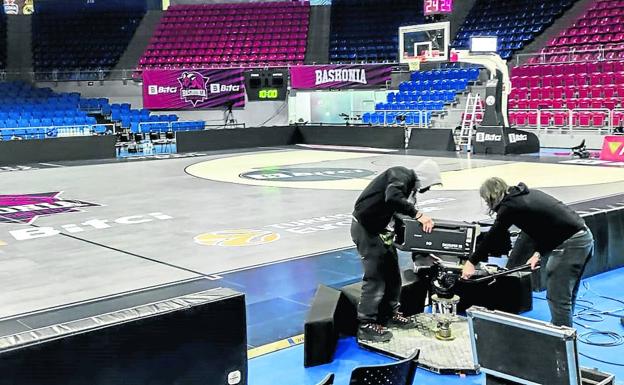 Operarios de televisión desmontan una cámara a pie de pista durante la tarde de ayer en el Buesa Arena. 
