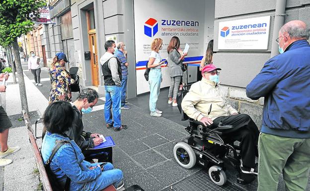 Sólo con cita previa. Ciudadanos hacen cola para acceder a la oficina de Zuzenean en la calle Ramiro de Maeztu en Vitoria./Igor Aizpuru