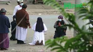 Moja bat belauniko jarri da Birmaniako militarren aurrean, umeak hil ez ditzaten