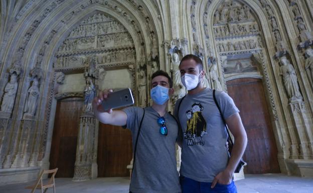 Dos turistas se inmortalizan en el pórtico de la catedral Santa María el pasado verano./Blanca Castillo