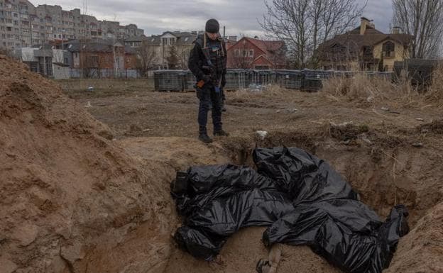 A man looks at bags containing the bodies of civilians in Bucha.