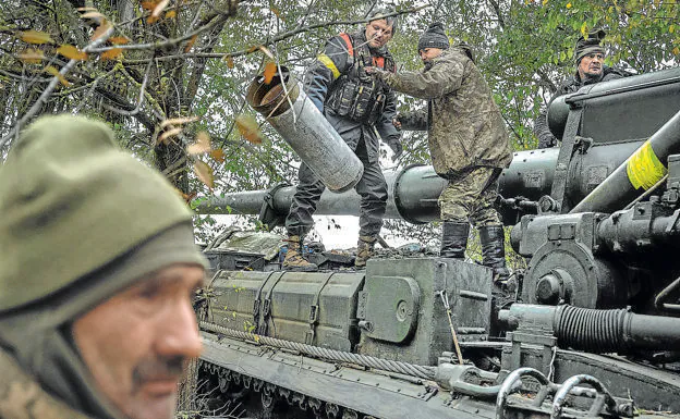 Ukrainian soldiers dismantle an artillery piece abandoned by the Russians after their withdrawal. 