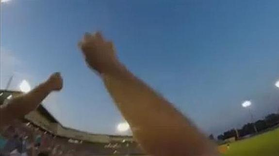 Un aficionado atrapa una pelota desviada durante un partido