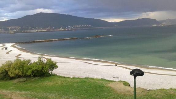 Uno bajo cero y granizo en la playa a las puertas de mayo